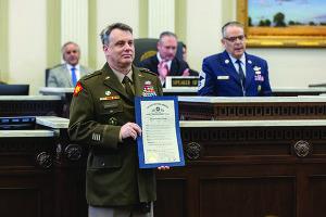 Major General Thomas H. Mancino holding the citation on the Oklahoma House floor.
