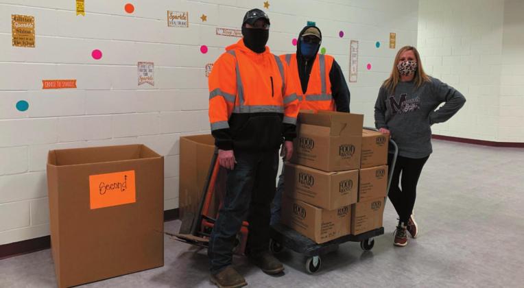 Lower Elementary school secretary, Laura Vollmer with volunteers from Ditch Witch loading the food drive boxes.