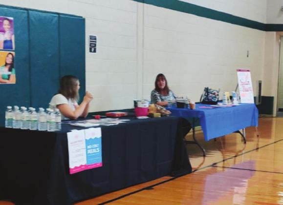 Seen above are staff and volunteers participating in the Noble County Family YMCA’s Wellness Fair, held in conjunction with several area businesses and organizations. Below are two children with ‘The Lion’ as they wait to fill their scavenger hunt like cards before receiving a free sno-cone.