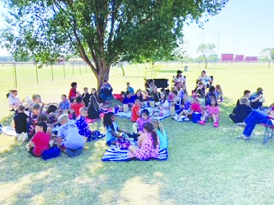 Students participated in a picnic lunch under trees at the Morrison park. Below, Morrison educators, seen below, found creative ways to engage students in learning about Arbor Day.
